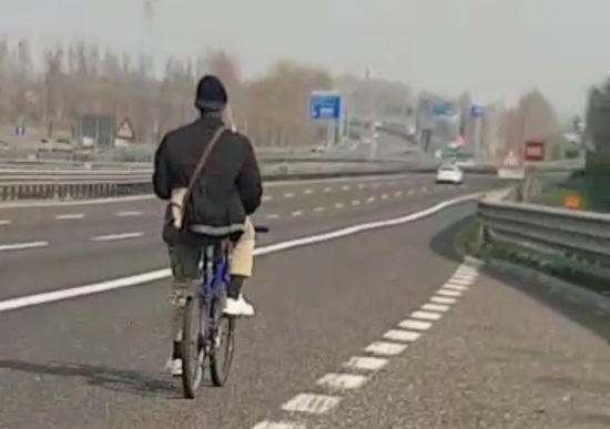 africano in bicicletta autostrada